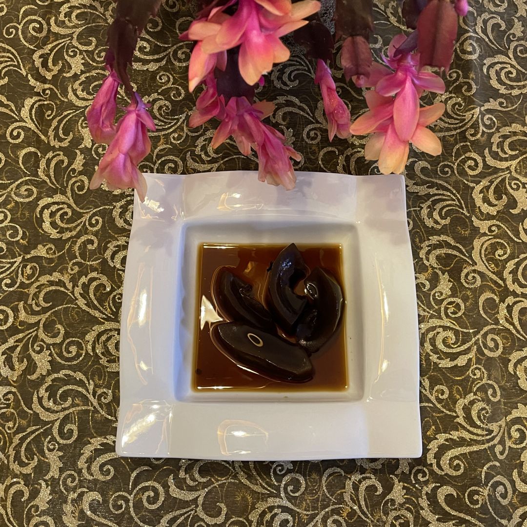 Frasco de dulce de lechosa casero con tiras de papaya en almíbar dorado.