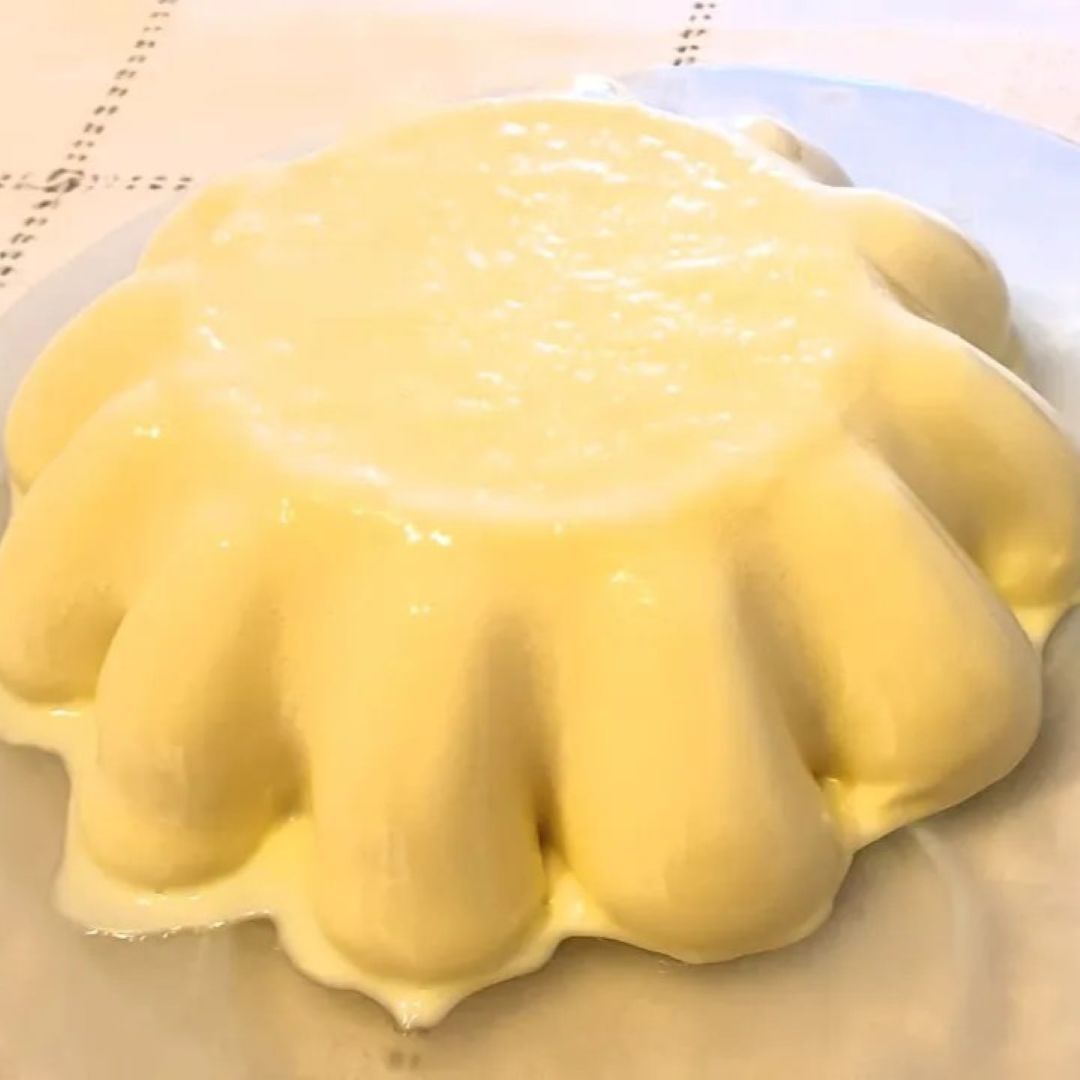 Mousse de melocotones en molde transparente, con textura cremosa y gajos de fruta, lista para servir como postre.